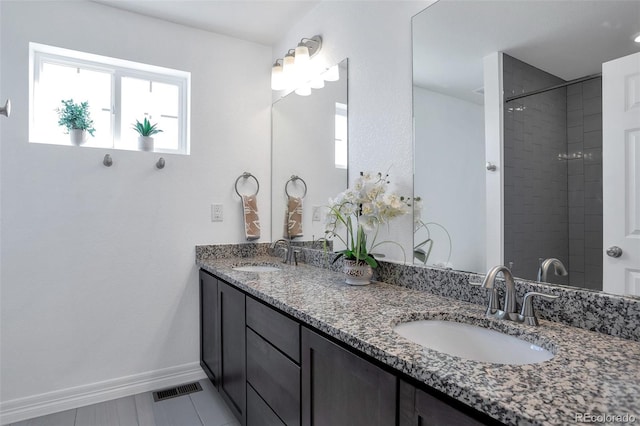 bathroom with vanity and a tile shower