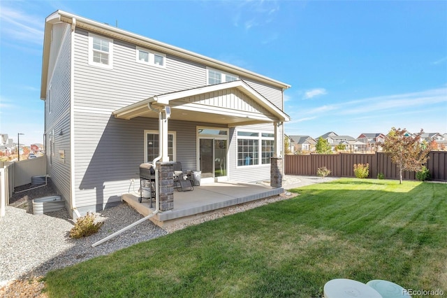 back of house with a patio and a lawn