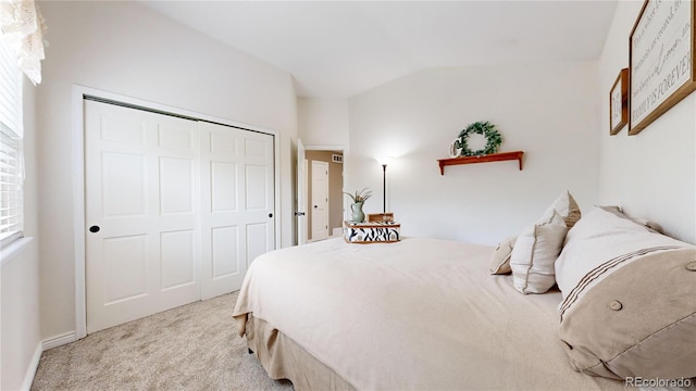 bedroom featuring light carpet, a closet, and lofted ceiling