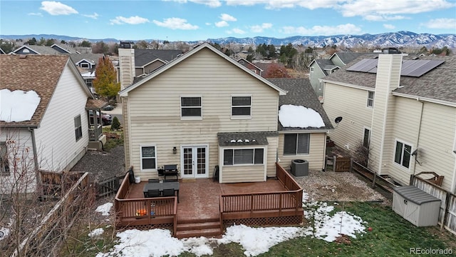 rear view of house featuring a deck with mountain view, french doors, and cooling unit