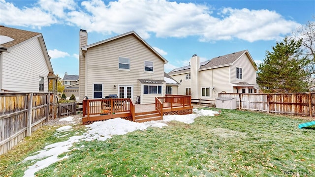 back of property with a lawn and a wooden deck