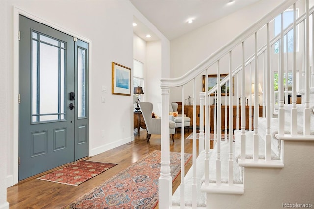 foyer entrance featuring stairs, recessed lighting, baseboards, and wood finished floors