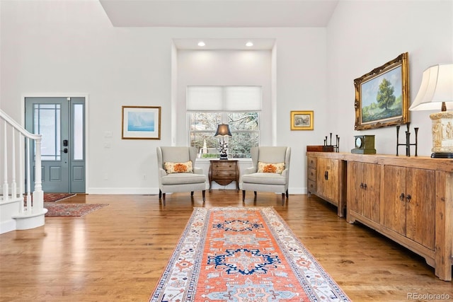 living area featuring recessed lighting, stairway, baseboards, and light wood finished floors