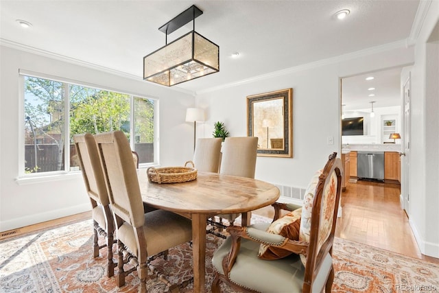 dining space featuring baseboards, ornamental molding, recessed lighting, and light wood-style flooring