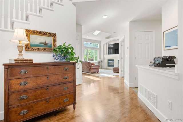 interior space featuring baseboards, light wood finished floors, and visible vents