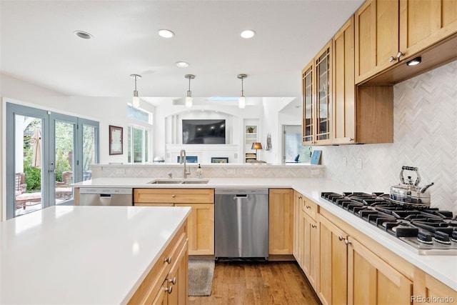 kitchen featuring light brown cabinetry, appliances with stainless steel finishes, a sink, and light countertops