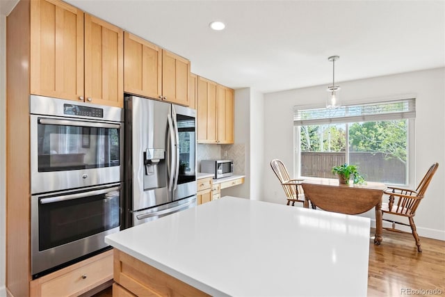 kitchen featuring backsplash, light brown cabinetry, appliances with stainless steel finishes, light wood-type flooring, and recessed lighting
