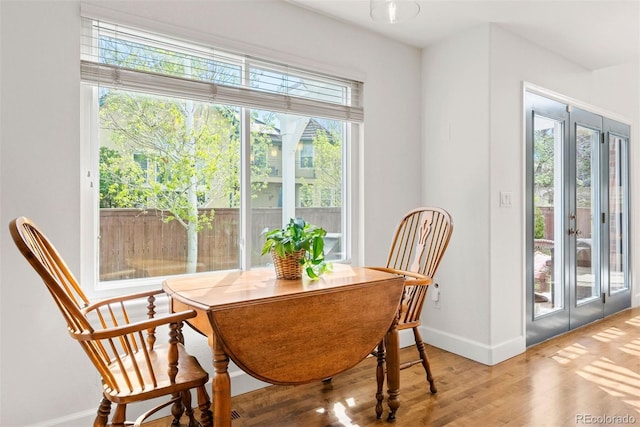 dining space with baseboards and wood finished floors