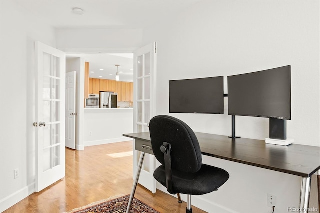 office space featuring light wood-style floors, baseboards, and french doors