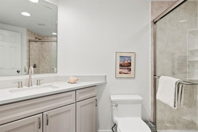 bathroom with toilet, a shower stall, and vanity