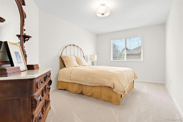 bedroom with baseboards and light colored carpet