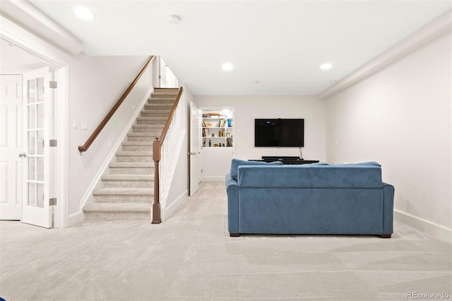 living room featuring recessed lighting, baseboards, light colored carpet, and stairway