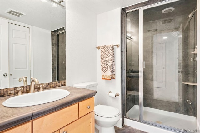 bathroom with vanity, toilet, tile patterned floors, a shower stall, and visible vents