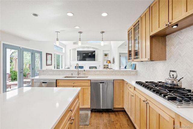 kitchen featuring a sink, appliances with stainless steel finishes, plenty of natural light, and light countertops