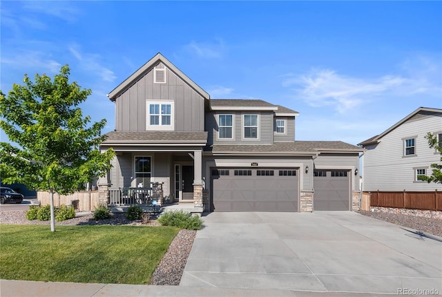 view of front of home with a garage, a front yard, and covered porch