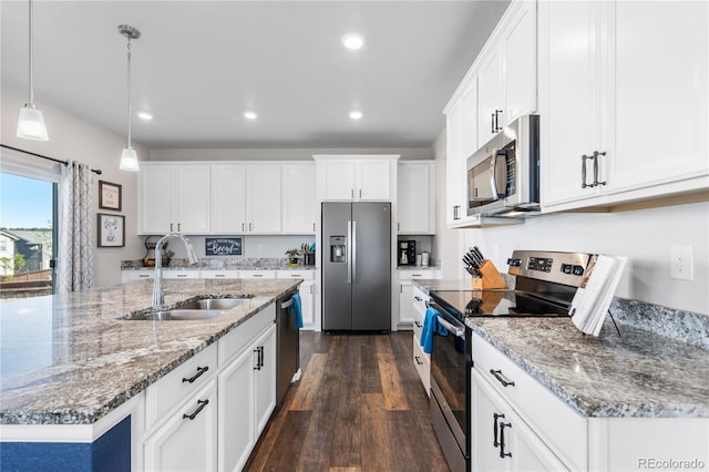 kitchen with sink, white cabinetry, a center island with sink, pendant lighting, and stainless steel appliances