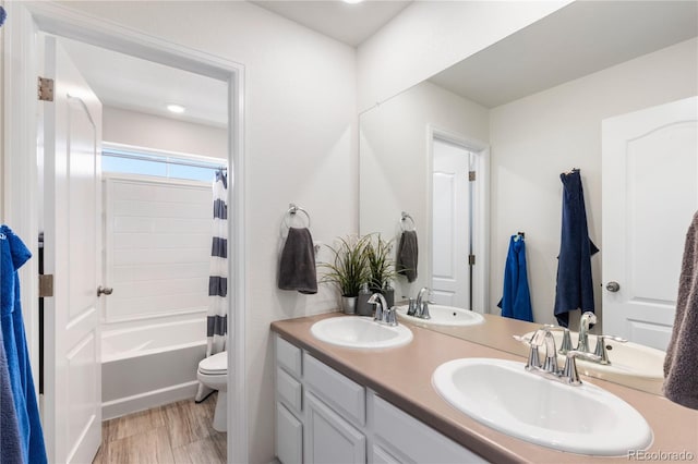 full bathroom with vanity, hardwood / wood-style flooring, toilet, and shower / bath combo with shower curtain