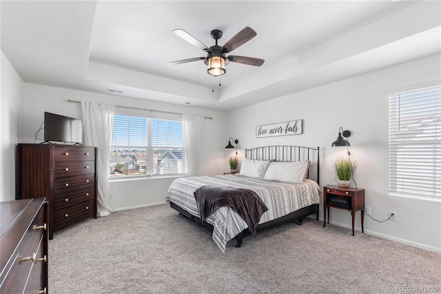 bedroom featuring carpet floors, ceiling fan, and a tray ceiling