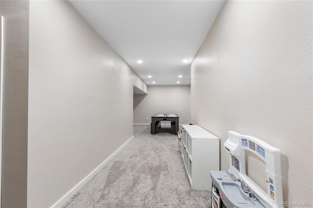 hallway with heating unit and light colored carpet