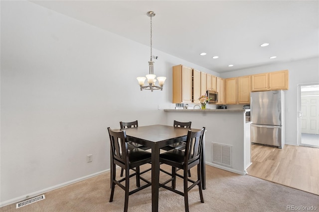 15612 E 96th Way Unit 21D, Commerce City, CO 80022 - dining space with an inviting chandelier, light colored carpet, and visible vents
