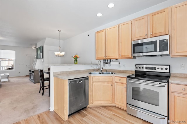 15612 E 96th Way Unit 21D, Commerce City, CO 80022 - kitchen with a sink, a peninsula, light brown cabinetry, light countertops, and appliances with stainless steel finishes
