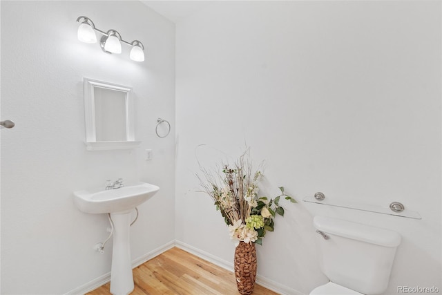 15612 E 96th Way Unit 21D, Commerce City, CO 80022 - bathroom featuring baseboards, toilet, and wood finished floors