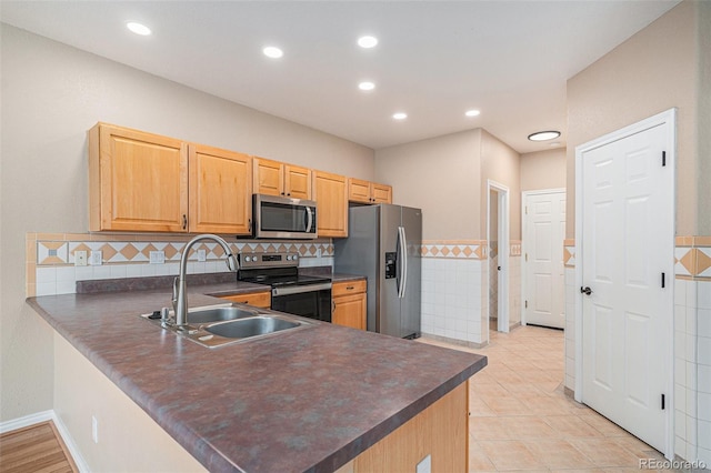 11862 W Stanford Pl, Morrison, CO 80465 - kitchen featuring appliances with stainless steel finishes, dark countertops, a sink, a peninsula, and recessed lighting