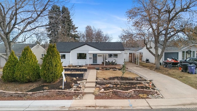 ranch-style home with a porch, roof with shingles, and driveway