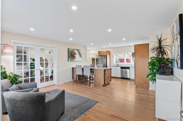 living room featuring recessed lighting, french doors, and light wood finished floors