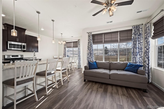 living room featuring ceiling fan and dark hardwood / wood-style flooring