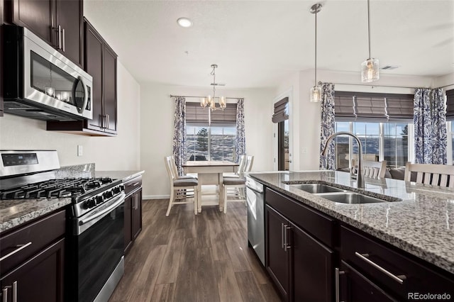 kitchen featuring stainless steel appliances, a wealth of natural light, hanging light fixtures, sink, and dark wood-type flooring