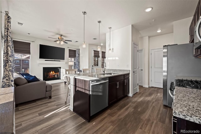 kitchen with sink, stainless steel dishwasher, dark hardwood / wood-style floors, dark brown cabinets, and decorative light fixtures