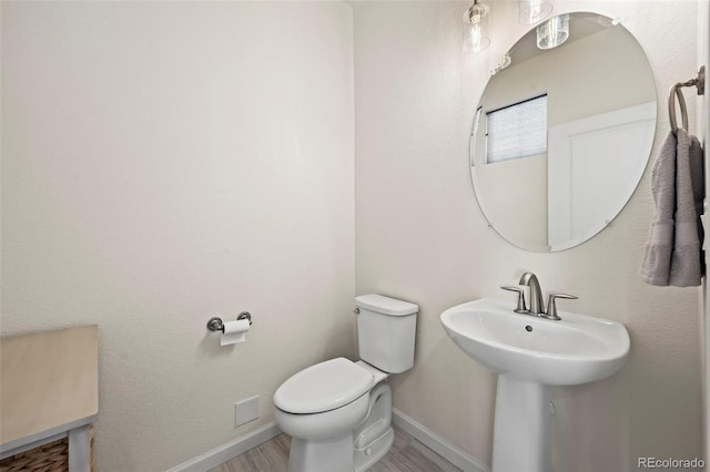 bathroom featuring wood-type flooring, sink, and toilet