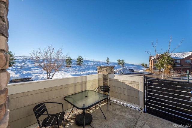 snow covered patio with a balcony