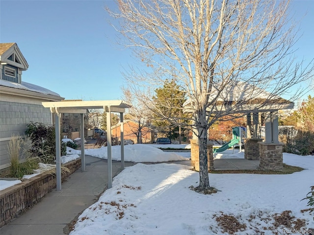 yard layered in snow with a playground