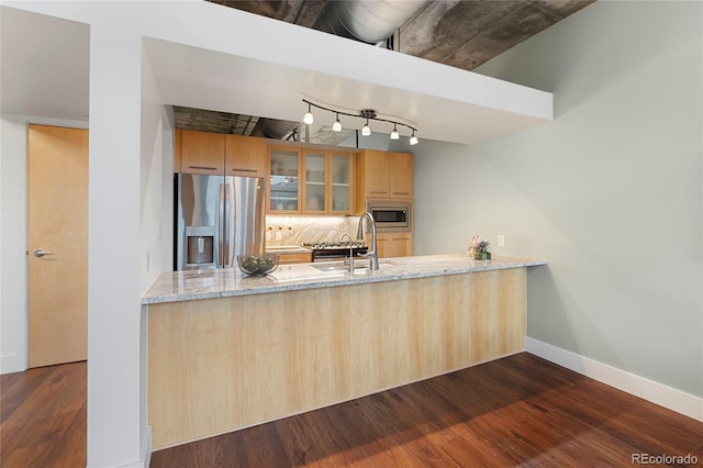 2100 16th St Unit 600, Denver, CO 80202 - kitchen with stainless steel appliances, a sink, a peninsula, light stone countertops, and dark wood-style floors