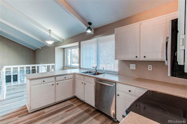 kitchen featuring vaulted ceiling with beams, stainless steel appliances, a sink, light wood-type flooring, and a peninsula