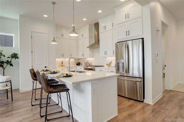 16550 Umatilla Pl, Broomfield, CO 80023 - kitchen featuring stainless steel appliances, wall chimney exhaust hood, a sink, light wood-style flooring, and recessed lighting