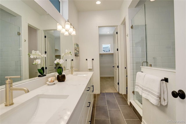 16550 Umatilla Pl, Broomfield, CO 80023 - bathroom featuring tile patterned floors, a shower stall, recessed lighting, double vanity, and a spacious closet