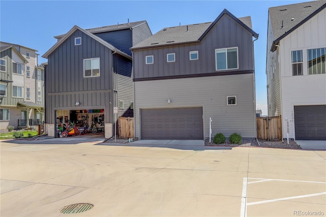 16550 Umatilla Pl, Broomfield, CO 80023 - view of front facade featuring board and batten siding, driveway, a garage, and fence