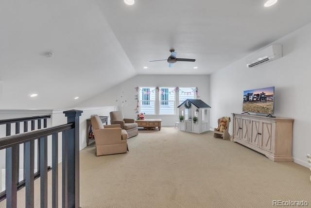 16550 Umatilla Pl, Broomfield, CO 80023 - living area with carpet floors, a ceiling fan, vaulted ceiling, a wall unit AC, and recessed lighting