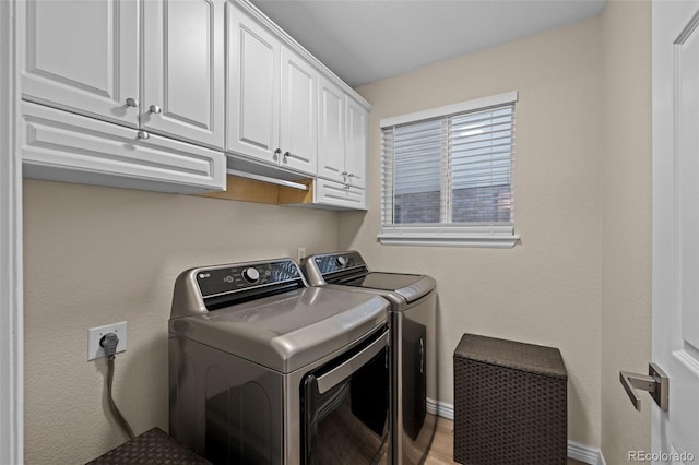 laundry area featuring cabinet space, washer and clothes dryer, and baseboards