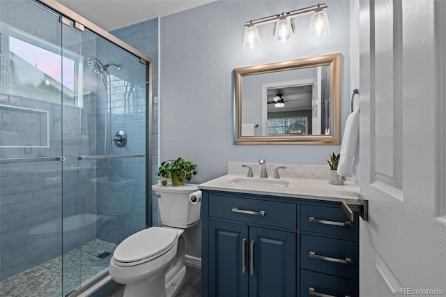 full bath featuring a stall shower, baseboards, vanity, and toilet