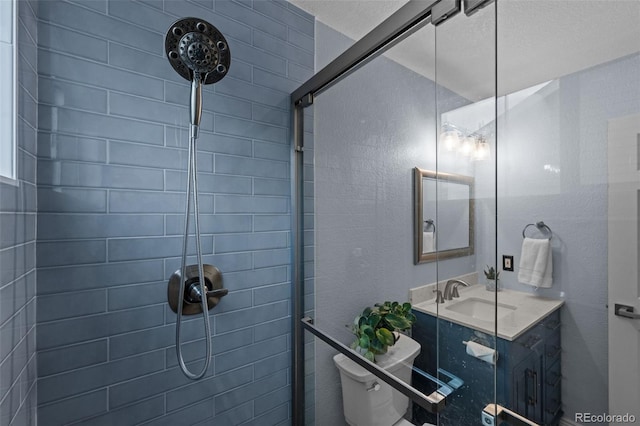 bathroom featuring tiled shower, vanity, and toilet