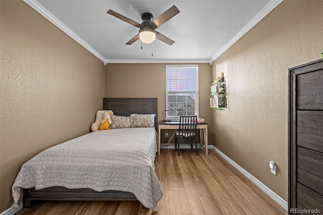 bedroom featuring baseboards, a textured wall, light wood-style flooring, a textured ceiling, and crown molding