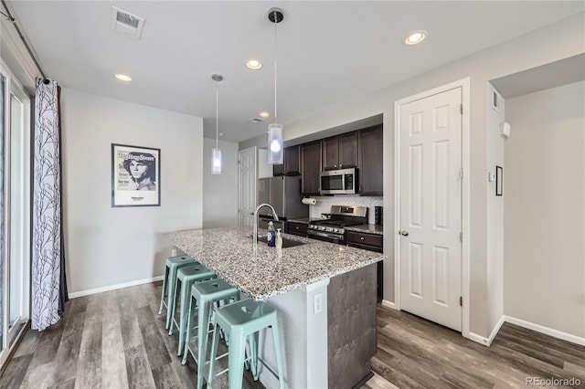 623 S Pitkin Ct, Aurora, CO 80017 - kitchen with stainless steel appliances, dark wood finished floors, visible vents, and dark brown cabinetry