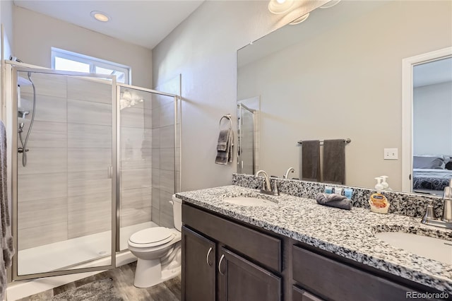 623 S Pitkin Ct, Aurora, CO 80017 - ensuite bathroom featuring a stall shower, a sink, and wood finished floors