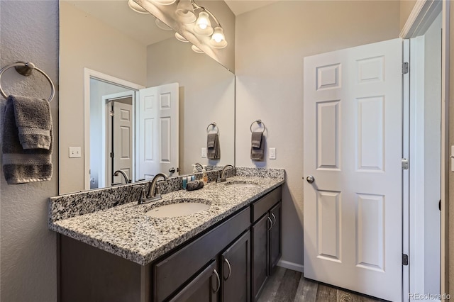 623 S Pitkin Ct, Aurora, CO 80017 - bathroom with baseboards, double vanity, a sink, and wood finished floors