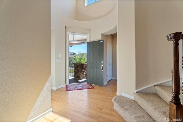 foyer with light hardwood / wood-style flooring and a high ceiling