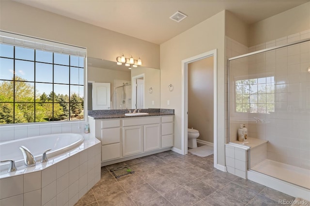 full bathroom with toilet, vanity, a healthy amount of sunlight, and shower with separate bathtub